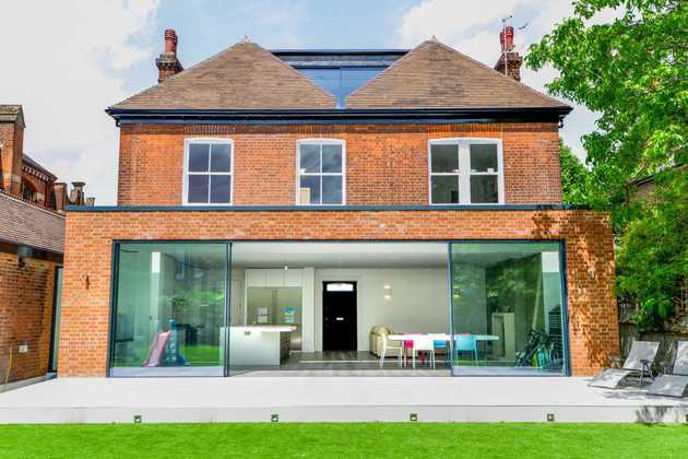 Red brick house with glass door and back terrace 