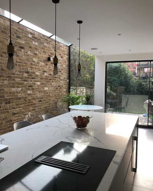 Modern kitchen with kitchen island and brick wall